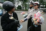 A policewoman hands a motorist a rose to mark Valentine's Day in Jakarta, February 14th, 2012. The holiday is considered haram or forbidden in Indonesia's Aceh province. [Reuters]