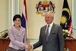 Thai Prime Minister Yingluck Shinawatra and her Malaysian counterpart, Najib Razak, shake hands after a joint news conference in Putrajaya near Kuala Lumpur on February 20th, 2012. Najib pledged that Malaysia would help Thailand resolve violence in its restive southern provinces. [Reuters]