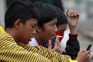 Seorang pelajar Indonesia merokok di stasiun kereta di Jakarta pada tanggal 24 Mei. Para advokat perlindungan anak di Indonesia berencana mengajukan gugatan perdata untuk mendorong terbentuknya peraturan yang lebih keras melawan anak yang merokok. [Beawiharta/Reuters] 