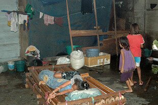 This building in Passo Village, a Christian area near Ambon City, was meant as temporary housing for people displaced by violence in Ambon in 2002. But families like the one pictured here have never left, due to security fears, new job opportunities and lingering trauma. [Petrus Oratmangun/Khabar].