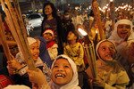 Children march through the streets carrying torches to mark the end of the Muslim fasting month of Ramadan and the start of Idul Fitri celebrations in Jakarta on August 30th, 2011. This year both Nahdlatul Ulama and Muhammadiyah Muslims will likely celebrate the event on the same day. [Supri/Reuters].