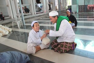 Abdulrohman Hayeema, a father of five, makes a zakat donation of 2.7kg of rice to 6-year-old Sahabudin Kadasa at the Ansulna Mosque in Betong. An orphan since he was 2, Sahabudin is a student at the Bantaya School in nearby Ruesoh district, Narathiwat. 