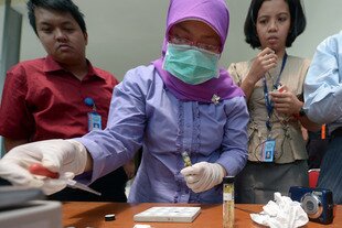 Officials of Indonesia's National Narcotics Agency (BNN) test methamphetamine during a February 7th press conference in Jakarta on recent smuggling attempts. BNN officials are concerned that drug use by celebrities is setting the wrong example for the nation's youth. [Adek Berry/AFP]