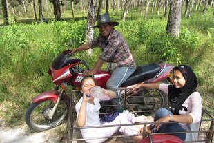 Noot Nafarang, on motorbike, runs the Ban Bang Rong Goat Co-op and Saimai Ridraksa (right) provides tours of the community in Phuket. Ban Bang Rong remains sustainable through ecotourism as the rest of the island undergoes more commercial development for tourism. [Somchai Huasaikul/Khabar]