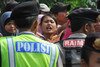 A Muslim resident (centre) shouts at Christian worshippers from the Filadelfia Batak Christian Protestant Church as they attempt to hold a Christmas mass on their property at Jejalen Jaya village in Bekasi, West Java. The local Forum for Religious Harmony (FKUB) has announced it will ask Bekasi residents to uphold interfaith harmony, in a bid to reduce friction between different faith communities. [Adek Berry/AFP]