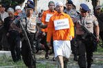 Para tersangka teroris Bayu Setyono (depan) dan Firman Firmansyah ditangkap pada tanggal 3 April di Solo, Jawa Tengah. Dengan semakin terfragmentasi dan semakin gelap para kelompok ekstrimis, kekhawatiran telah meningkat atas bahaya "radikalisasi diri" melalui internet. [Anwar Mustafa/AFP].