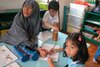 A teacher overlooks a reading and writing session at Al Hidayah, one of the leaders in a new wave of Islamic pre-schools that stress modern learning techniques. [Grace Chen/Khabar]