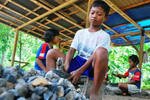 Anak-anak di Kabupaten Purwarejo, Jawa Tengah, memecah batu untuk digunakan dalam konstruksi. Di seluruh Indonesia, sekitar 300.000 anak bekerja untuk membantu menghidupi keluarga mereka. Sebuah program pemerintah membantu buruh anak kembali ke sekolah. [Sarwo S/Khabar].