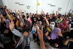 PRT Indonesia mengangkat tangan mereka selama pemeriksaan polisi mengenai kelayakan mereka untuk bekerja di luar negeri, di Bekasi, Jawa Barat, pada tanggal 22 Juni 2011. Menurut pemerintah, jumlah tenaga kerja Indonesia di Arab Saudi adalah 1,4 juta. [Adek Berry/AFP].