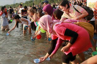 Visitors release sea turtle hatchlings at Kuta Beach on June 22nd as part of the Bali Big Eco Weekend. The event was aimed at raising awareness about the need to keep beaches clean, both in order to protect wildlife and to attract tourists vital to the economy. [Photo Courtesy of Garuda Indonesia]