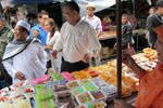 Imam Yakob Raimanee, 49, (kiri) berbelanja manisan di sebuah pasar Pattani tahun lalu. Yakob, yang sangat dihormati dalam masyarakat dan seorang kritikus kekerasan, ditembak mati pada hari Senin (5 Agustus) meskipun adanya gencatan senjata Ramadhan yang disepakati dengan Barisan Revolusi Nasional (BRN), salah satu kelompok pemberontak utama di Ujung Selatan. [Rapee Mama/Khabar]