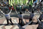 Polwan melakukan tarian "Gangnam Style" sementara mengamankan unjuk rasa Hari Buruh di depan Balai Kota Surabaya, Jawa Timur pada tanggal 1 Mei. Kapolri Timur Pradopo mengatakan dia akan mencabut surat keputusan yang melarang polwan mengenakan jilbab saat bertugas. [Juni Kriswanto/AFP].