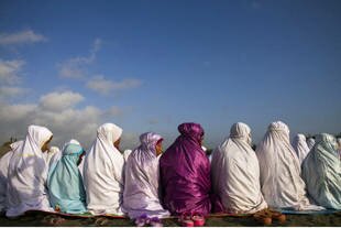 Para wanita menghadiri sholat pagi Idul Fitri di dekat pantai di Bantul, Yogyakarta, Kamis (8 Agustus). Puluhan juta umat Islam di seluruh Indonesia merayakan hari raya itu setelah berakhirnya Ramadhan. [Suryo Wibowo/AFP]