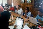 Imam Syuja' (berkemeja putih), mantan anggota DPR dari Aceh, berbicara pada sebuah diskusi meja bundar dengan sejumlah aktivis masyarakat sipil di Banda Aceh pada tanggal 15 Agustus 2013. Diskusi ini merupakan cerminan atas delapan tahun perdamaian di Aceh. [Nurdin Hasan/Khabar].