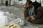 Pasangan suami istri di Suriah berduka di depan jenazah yang dibungkus kafan, setelah serangan yang diduga gas beracun oleh pasukan pro Assad di Ghouta timur, di pinggiran Damaskus pada tanggal 21 Agustus. Pihak oposisi mengatakan ribuan orang, sebagian besar wanita dan anak-anak, tewas dalam serangkaian serangan kimia yang diluncurkan oleh rezim itu. [Foto AFP/Shaam News]