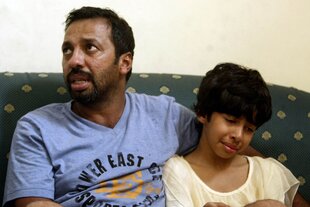 Iranians Mohammad Hardani, 36, and his daughter Athena Hardani, 10, are reunited at a hotel in Juanda, Indonesia on December 23rd, 2011 after surviving the sinking of an Australia-bound people-smuggling boat five days earlier. At least 90 migrants died in the incident. Indonesia and Malaysia recently cancelled visa-on-arrival policies for Iranians to stem people- and drug-smuggling, authorities say. [Juni Kriswanto/AFP]