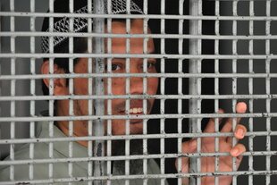 Jemaah Islamiyah (JI) suspect Syaifudin Zuhri looks out from a holding cell at South Jakarta court in April 2010. JI emerged from home-grown Islamic hard-line group Darul Islam, which took root in Indonesia in the 1950s, says terrorism expert Solahudin. [Bay Ismoyo/AFP] 