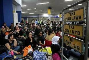 Indonesian migrant workers returning from Malaysia and Saudi Arabia await the next leg of their homeward journeys at Jakarta's Tanjung Priok Port in January. [Alisha Nurhayati/Khabar]
