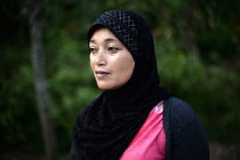 Mariyah Nibosu, whose husband was shot dead in 2009 by unknown gunmen, stands outside her home in September 2013 in the state-run 'widows' village' of Rotan Batu, 20km from Narathiwat. "Women suffer a lot here," she said. "But we are strong. We have to feed our children by ourselves. We have to survive." [Christophe Archambault/AFP]