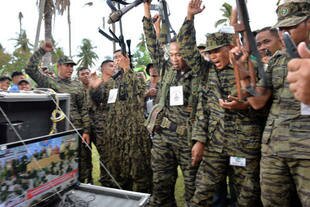 Moro Islamic Liberation Front (MILF) rebels react to a live telecast of the signing of a peace agreement during a rally at Camp Darapanan in Sultan Kudarat, Mindanao. [Ted Aljibe/AFP]