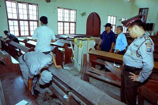 Petugas polisi dan staf GKPI (Gereja Kristen Protestan Indonesia) di Medan, memeriksa di tengah kerusakan yang diduga disebabkan oleh bom rakitan pada bulan Mei 2000. Awaluddin Sitorus, seorang warga Indonesia yang ditahan di Brunei, telah diduga berkaitan dengan pemboman gereja yang berlangsung di Medan 14 tahun yang lalu. [Faesal/AFP]