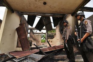 Para perwira polisi menjaga reruntuhan kantor kecamatan Sindue Induk di Donggala, Sulawesi, setelah kebakaran tanggal 16 April menghancurkan bangunan dan kotak-kotak suara di dalamnya. [M. Taufan S.P. Bustan/Khabar]