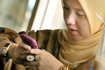 Seorang warga Jakarta mengunjungi situs jejaring sosial dengan telepon genggamnya. Kaum muda Indonesia antusias menanggapi sebuah polling online yang memungkinkan mereka untuk memilih anggota kabinet Presiden terpilih Joko Widodo. [Bay Ismoyo/AFP] 