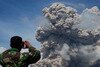 A member of the Indonesian military watches Mount Sinabung erupt October 25th in North Sumatra. A new Indonesian Red Cross mobile phone application will help people prepare for disasters. [Sutanta Aditya/AFP] 