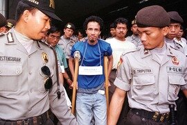  Taufik Abdul Halim walks with police in Jakarta in 2001. He returned to Malaysia last month after serving 12 years in an Indonesian prison. [AFP] 
