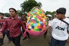  Christians carry a giant egg papered with messages for the president after an Easter service outside the presidential palace in Jakarta on March 31st, 2013. Now, the new government is drafting a bill to shield Indonesia's religious minorities and unofficial religious groups from intolerance, Minister of Religious Affairs Lukman Hakim Saifuddin says. [Adek Berry/AFP] 