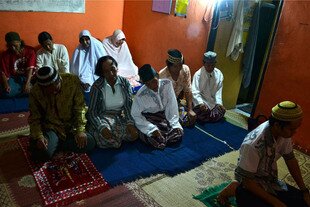 A cleric leads prayers at a private home in Yogyakarta. The group gathers weekly to study the Qur'an. In Indonesia, 'waria' are classified as mentally handicapped and often are subjected to harassment. [Photo by Pradipta Lakshmi]