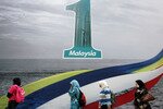 Muslim women in Kuala Lumpur walk past a billboard with the 
