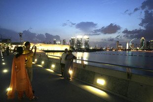 Tourists from South Asia take photos from the dam that runs across the Singapore River's mouth at Marina Bay. International tourist arrivals in Asia have skyrocketed in recent years, with South and Southeast Asia leading the way. [Reuters]