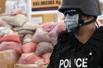 A Thai policeman guards bags of methamphetamine pills during the 40th Destruction of Confiscated Narcotics ceremony in Ayutthaya province, 80 km (50 miles) north of Bangkok on September 17th, 2011. A UN study released Tuesday highlighted growing meth and ecstasy production and abuse in Thailand and Indonesia. [Reuters]
