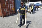 A Malaysian customs officer carries elephant tusks that were seized in Port Klang outside Kuala Lumpur on December 13th, 2011. [Bazuki Muhammad/Reuters]