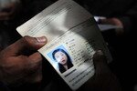 Pakistani authorities examine the passport of Jiang Hua, a Chinese national who was killed in Pakistan on February 28th. The Taliban has claimed responsibility for her killing. [Javed Khan]