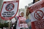 A woman holds up an anti-Lady Gaga poster in Jakarta on April 29th, 2012. The poster reads 