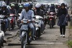 A woman walks on a sidewalk taken over by motorcycles in South Jakarta on April 2nd, 2012. [Enny Nuraheni/Reuters]