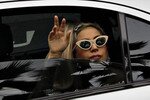 Lady Gaga waves to fans upon arriving at the JetQuay CIP (Commercially Important People) terminal at Changi Airport in Singapore on Saturday (May 26th). After threats by the Islamic Defenders Front (FPI) to disrupt her June 3rd concert in Jakarta with violence, her management canceled the show as a precaution. [Tim Chong/Reuters].