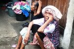 Two elderly women rest on a stoop in Kampung Pertanian Tengah in East Jakarta. The slum area is popularly known as Kampung Pengemis or Beggars' Village. Every Ramadan, it hosts seasonal beggars who come to Jakarta and other major cities seeking alms. [Zahara/Khabar].