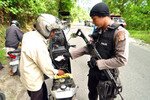 Local police in Poso stop a motorcyclist on January 16th, as part of the Kendali Maleo security operation focused on securing the region, enforcing the law, and providing social services. [Yenny Herawati/Khabar]