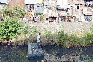 A volunteer cleans up Estero de Paco tributary in Manila. An Asian Development Bank report released Wednesday (March 13th) said despite strong economic growth, nearly two-thirds of the Asian-Pacific population has no clean, piped water at home. [Ted Aljibe/AFP]
