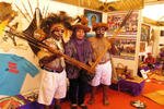 Wearing traditional Papuan paint and headpieces, Roni Haluk (right) and a colleague pose with a visitor at the Papua province booth for National Information Week 2013 in Medan. Roni is using the Internet to market his honey. [Photos by Ismira Lutfia Tisnadibrata/Khabar]