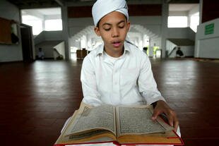 A Thai Muslim boy reads the Qur'an during the month of Ramadan at the Yala central Mosque on September 8th, 2008. Indonesia has announced it will give 50 scholarships to Thai Muslims to study at Islamic institutions in Indonesia. [Muhammad Sabri/AFP]