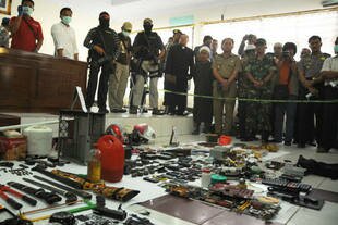 Police display homemade bombs, ammunition and weapons at Poso police headquarters on November 2nd, 2012. The items were seized during anti-terror operations two days earlier. In the wake of a June 3rd suicide bombing, Poso residents are more concerned than ever about terrorism in the region. [Achun/AFP]