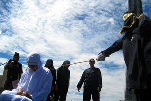 An Acehnese girl is caned after being found guilty of kissing in public, a serious violation under Sharia law. The punishment was carried out in front of the Al-Munawarrah Mosque in Jantho City, on the outskirts of Banda Aceh, on December 10th, 2010. [Nurdin Hasan/Khabar]