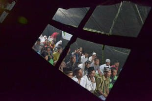Acehnese residents affected by recent earthquakes listen to a sermon in Ketol, Central Aceh on Tuesday (July 9th) on the first night of the Holy Month of Ramadan. Survivors in refugee camps are dealing with fever, diarrhoea and respiratory infections. [Sutana Aditya/AFP]