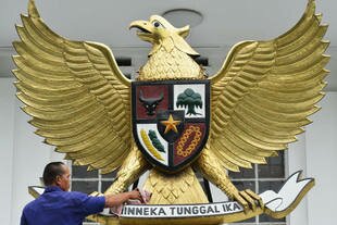 A man cleans the national symbol Garuda Pancasila on a roof in Jakarta in October 2012. It carries a shield representing Pancasila (five principles, including unity and democracy) and the national motto (unity in diversity). National broadcaster TVRI pledged to uphold Pancasila after its recent broadcast of a Hizbut Tahrir meeting drew outrage. [Bay Ismoyo/AFP]