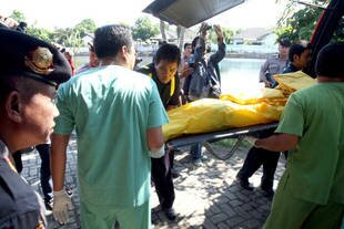 Hospital personnel carry the body bag bearing the corpse of a slain terrorist in Surabaya, East Java for forensic investigation Monday (July 22nd). The man and another suspect died in a gunfight with police. [Juni Kriswanto/AFP]
