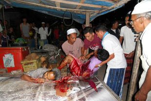 Onlookers watch as the bodies of Awae Nisaya (right), 38, and Maseng Moong, 42, are removed from a teashop in Lubo Bersa, Narathiwat. Two unidentified assailants armed with an assault rifle allegedly shot both men to death Tuesday (July 23rd). [Rapee Mama/Khabar]